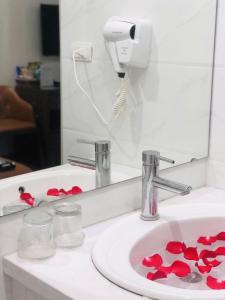 a bathroom sink with red decorations in front of a mirror at Bạch Dương Hotel Hà Nội in Hanoi