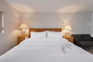 ウエスト・バンクーバーにあるStylish Scenic Oasis 3-Bed Suite West Vanの大きな白いベッドとソファのある寝室