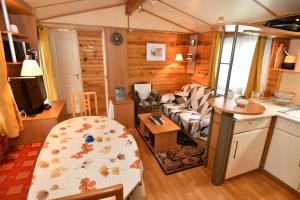 a living room with a couch and a kitchen at LA COMBE - Entre lacs et montagnes in Verchaix