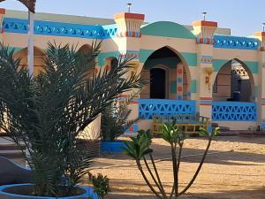 una casa en el desierto con plantas delante de ella en ATON PALACE Luxor, en Luxor