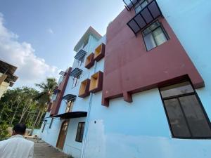 a man standing in front of a building at Hotel O DG College Chelambra in Ferokh +1 photo