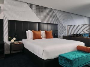 a bedroom with a large white bed and a couch at Movenpick Hotel Melbourne On Spencer in Melbourne
