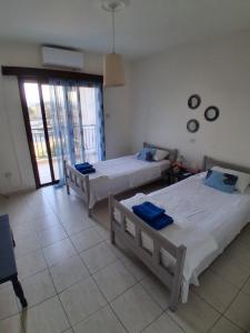 une chambre avec deux lits et une grande fenêtre dans l'établissement Maisonette Rock - Axiotheas - Meteora Heights, à Paphos 5 autres photos