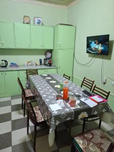 a kitchen with a table and chairs and a tv at Lucky hostel in Tashkent +4 photos