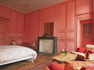 a bedroom with red walls and a bed and a fireplace at Maison Pistache in Le Dorat