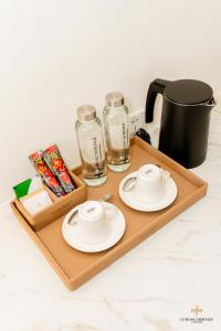 a wooden tray with two plates and glasses on it at Le Blanc Heritage Hotel in Kon Rung (1)