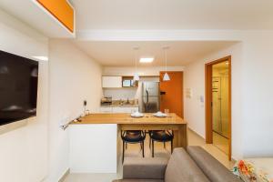 a kitchen and living room with a table and a couch at Studio 404 On São Mateus in Juiz de Fora