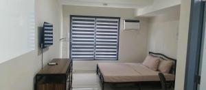 a small room with a bed and a window at Lei's Abode in Mandaue City +3 photos