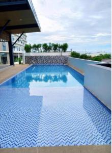 マンダウエ・シティにあるLei's Abodeの青いタイルの建物内のスイミングプール