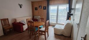 a living room with a table and chairs and a couch at Appart Soleil et montagne in Les Angles