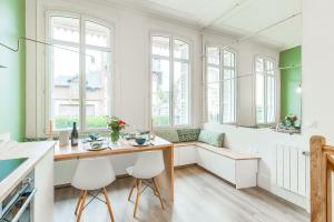 a kitchen with a table and chairs and windows at Appartement d'Antonin - 50m de la plage in Trouville-sur-Mer