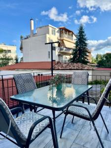a table and chairs sitting on a balcony with aperature at The Nest - Cozy Stay in Arcadia in Tripolis