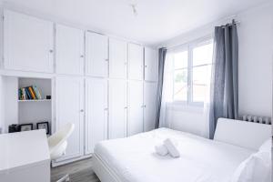 アルジャントゥイユにあるMaison Cosy - Tout équipé - à 15 min de La défenseのベッドと窓のある白い寝室