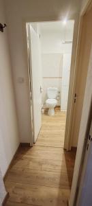 an empty bathroom with a toilet in a hallway at Appart Soleil et montagne in Les Angles +7 photos
