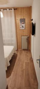 a bedroom with a bed and a television in a room at Soleil et montagne in Les Angles