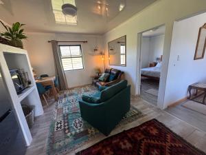 a living room with a green couch and a bedroom at Tulbagh Tiny Homes in Tulbagh