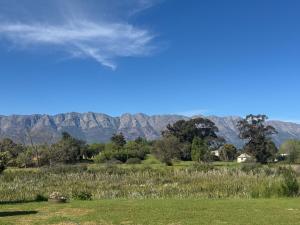 a field of grass with mountains in the background at Tulbagh Tiny Homes in Tulbagh