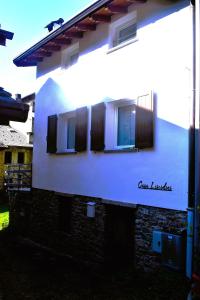 un edificio blanco con persianas negras en él en Casa Liscidini, en Aprica