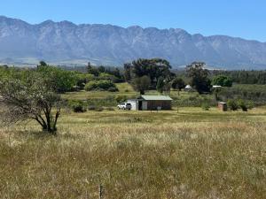 a car parked in a field with mountains in the background at Tulbagh Tiny Homes in Tulbagh +9 photos