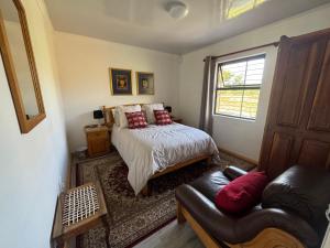 a bedroom with a bed and a couch and a window at Tulbagh Tiny Homes in Tulbagh