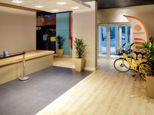 an office lobby with a surfboard on the wall at ibis budget Maceió Pajuçara in Maceió