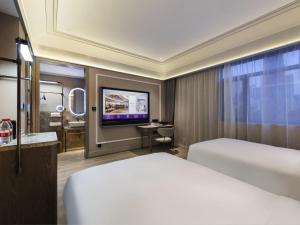 Una habitación de hotel con una cama y un televisor de pantalla plana. en Mercure Qingdao Downtown, en Qingdao 42 fotos más