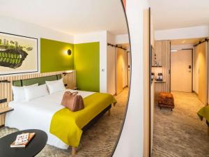 a hotel room with a large bed and a mirror at Mercure Katowice Centrum in Katowice