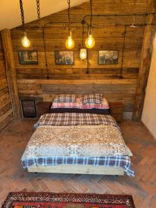 ein Schlafzimmer mit einem Bett in einem Zimmer mit Holzwänden in der Unterkunft Bieszczadzka Sielanka in Wojtkowa