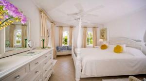 a white bedroom with a white bed and a mirror at ZenBreak Sugar Breeze B106 2bd in Saint James