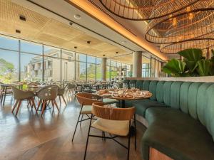 a restaurant with green booths and tables and chairs at Sofitel Barú Cartagena in Cartagena de Indias