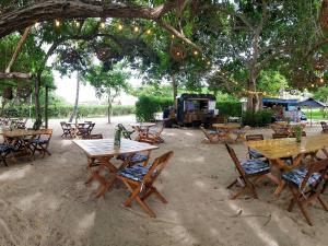 a group of wooden tables and chairs under a tree at Sofitel Barú Cartagena in Cartagena de Indias