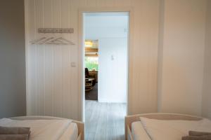 a bedroom with two beds and a door leading to a hallway at Haus Sonnenwinkel Ina in Dahme