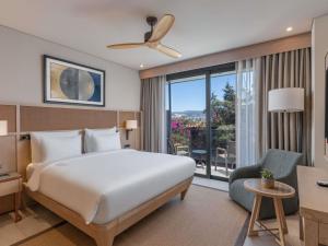 ein Hotelzimmer mit einem Bett und einem großen Fenster in der Unterkunft The Bodrum Hotel Yalıkavak - MGallery Collection in Yalıkavak + 204 Fotos