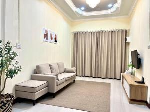 a living room with a couch and a tv at I'm Home Narathiwat in Narathiwat