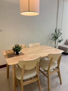 a wooden dining room table with chairs and a light fixture at I'm Home Narathiwat in Narathiwat +26 photos