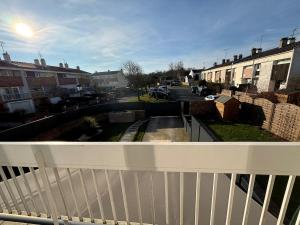 a balcony with a white fence and a street at Evasion Verdoyante Vue sur jardin avec balcon et parking in Montigny-le-Bretonneux +4 photos