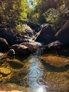 ein Wasserlauf mit Felsen und Bäumen in der Unterkunft Casa na Cachoeira das Fadas - Matutu, Aiuruoca - MG in Aiuruoca