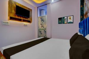 a bedroom with a bed and a tv on a wall at HOTEL O TWINS PALACE in Kaliānpur