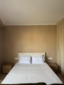 a bedroom with a large bed with white sheets and pillows at Nest Studio in Katerini