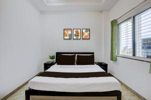 a bedroom with a large bed and two windows at HOTEL O SPACE INN NH 44 in Pānchgaon +32 photos