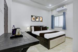 a bedroom with a bed and a wooden table at HOTEL O SPACE INN NH 44 in Pānchgaon