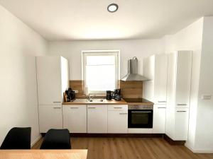 オスナブリュックにあるCharming Holiday Apartment in Osnabrück 10102の白いキャビネット、シンク、窓付きのキッチン +9枚の写真