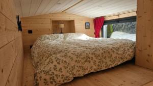 a bedroom with a bed in a wooden room at Tiny House Kota Grill & Sauna in Yébleron +18 photos