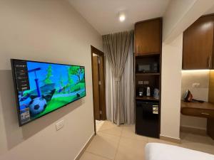 Una habitación con un televisor de pantalla plana en una pared. en فندق اقمار مدينة نصر Aqmar Hotel Nasr City, en El Cairo