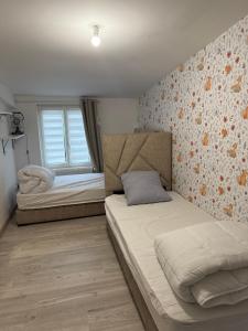 a bedroom with two beds and a window at Maison à la campagne in Mecquignies