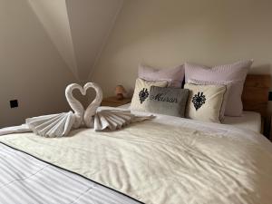 ein weißes Bett mit einer Herzdekoration darauf in der Unterkunft Muran Apt in Zakopane