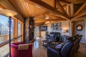 a living room with leather furniture and a wooden ceiling at A Nest With a View in Blowing Rock