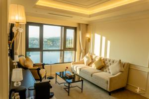 a living room with a couch and a large window at Le Blanc Heritage Hotel in Yen Bai