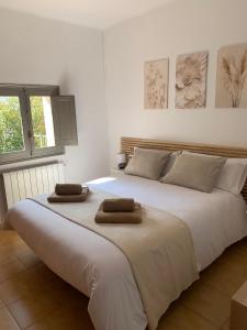 een groot wit bed met twee handdoeken erop bij Apartament La Plana in Campdevánol