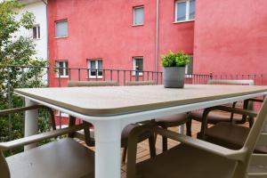 a table and chairs on a balcony with a red wall at Apartament La Plana in Campdevánol